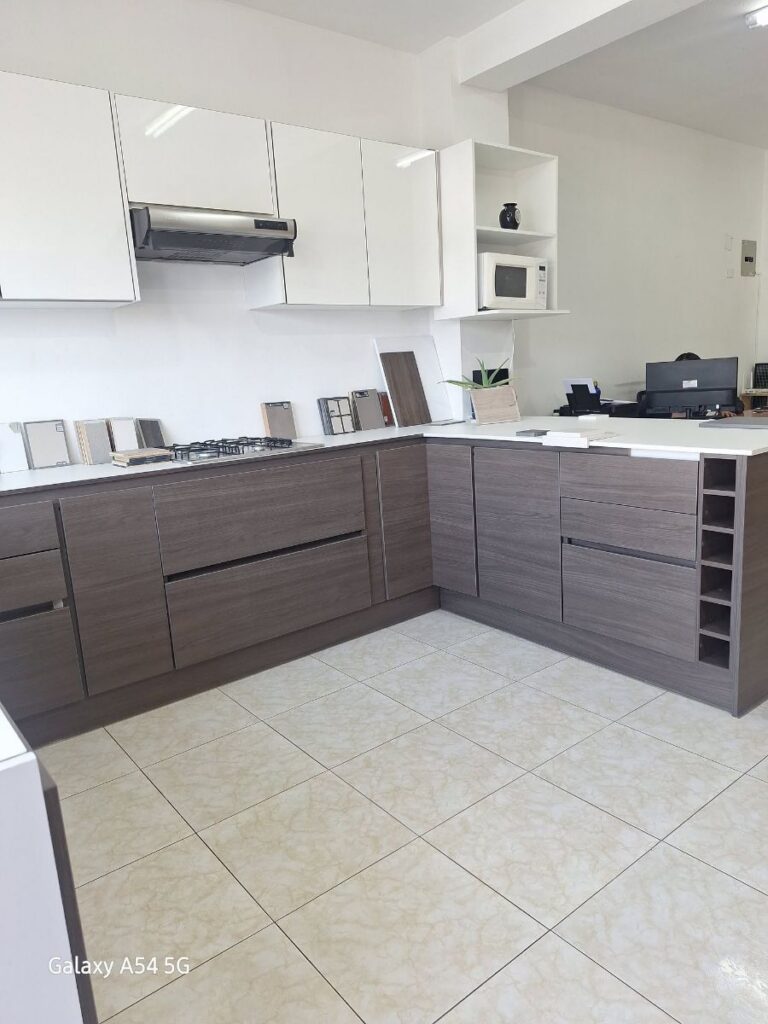 Cocina contemporánea en U con muebles gris ceniza, alacenas blancas brillantes y cava para vinos