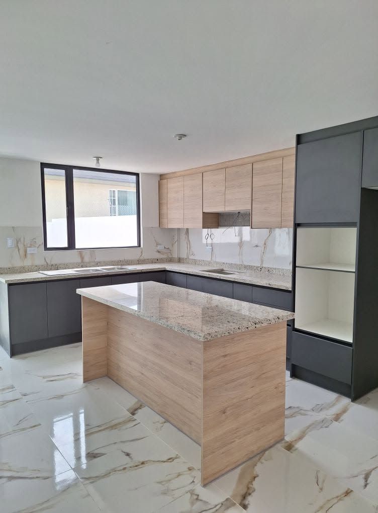 Cocina moderna bicolor gris grafito y roble claro con isla central de granito
