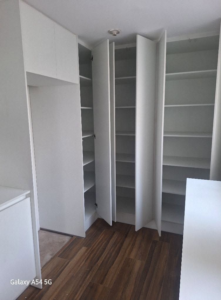 Vestidor blanco con puertas altas y repisas de piso a techo